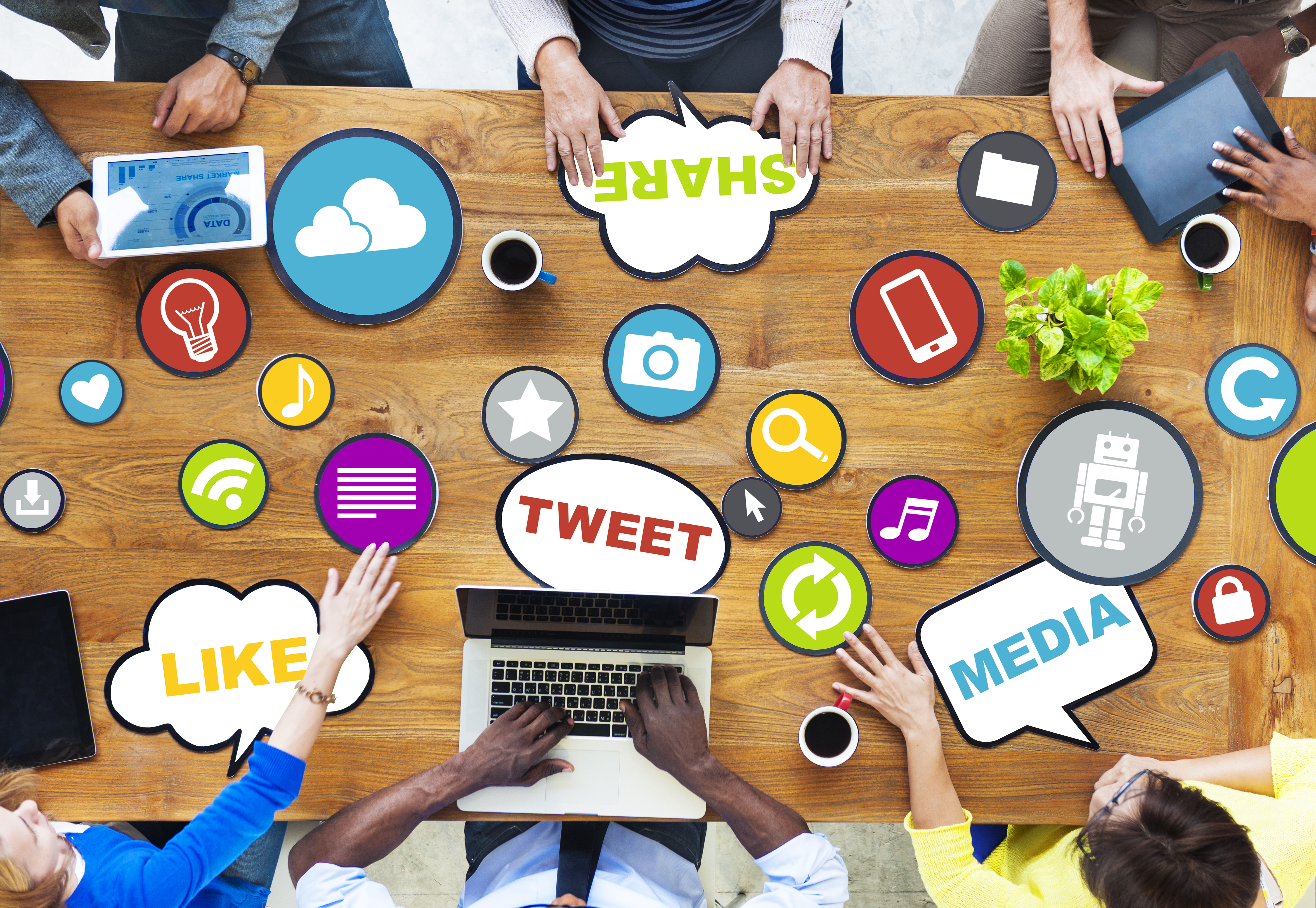 A social media meeting with several social media icons on the desk.